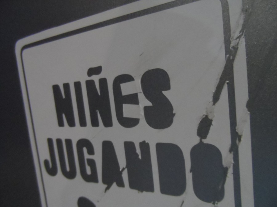 Letrero con el texto "niñes jugando"