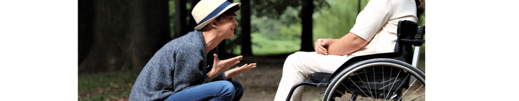 Imagen de dos personas en una divertida conversación, una de ellas utiliza silla de ruedas.